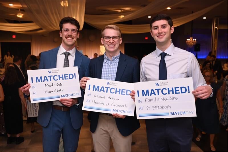 Alan Ford, Phil Bright, and Flynn Blanchet hold I Matched signs.