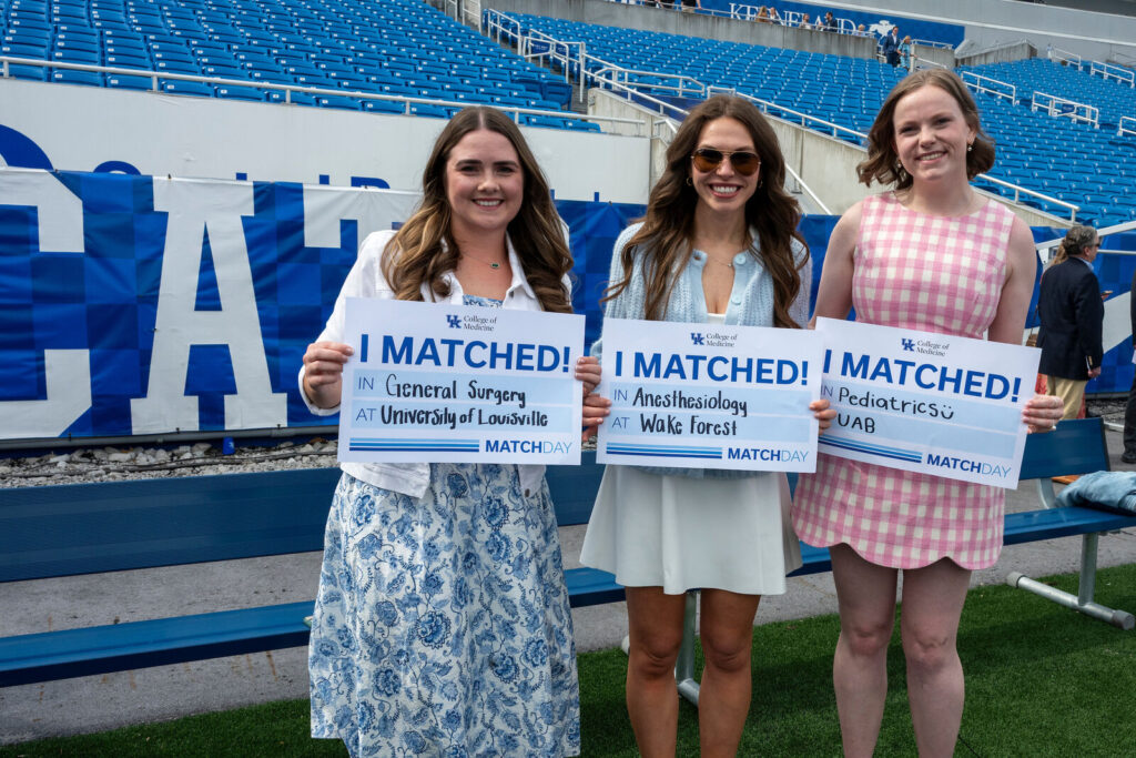 Emily Melcher, Jasarae McKinney, and Emmy Trammell hold I Matched signs.
