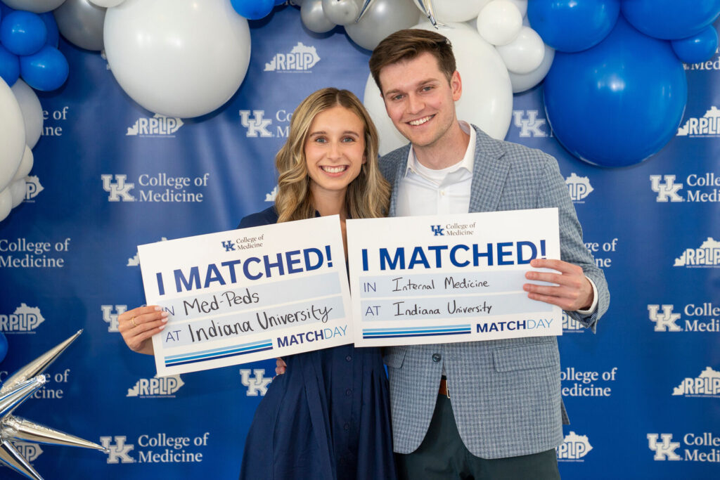 Olivia Back and fiancé Mason McGhee hold I Matched signs for Indiana University.