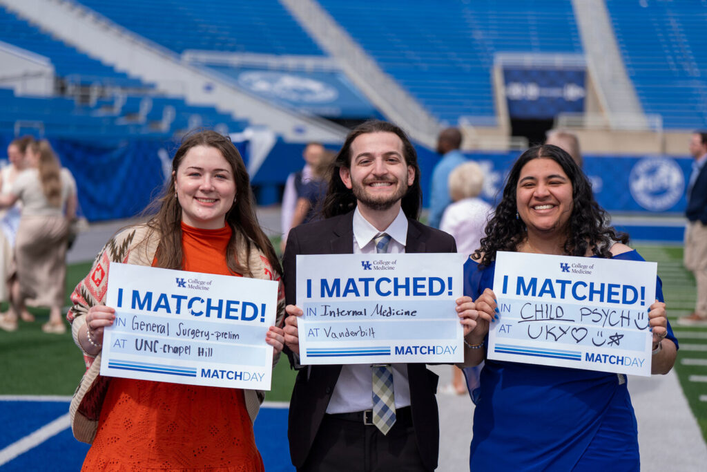 Rachel Mooney, Mardan Khashimov, and Supriya Challa hold I Matched signs.
