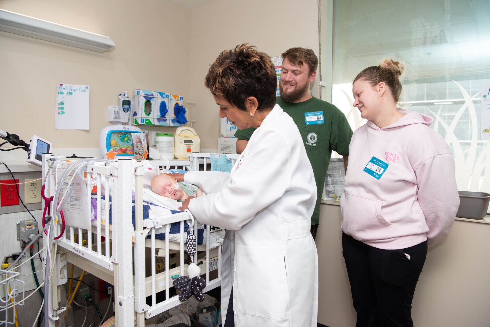 Tamina Singh, MD, checks on an infant in the NICU at Norton Children's Hospital while the baby's parents look on