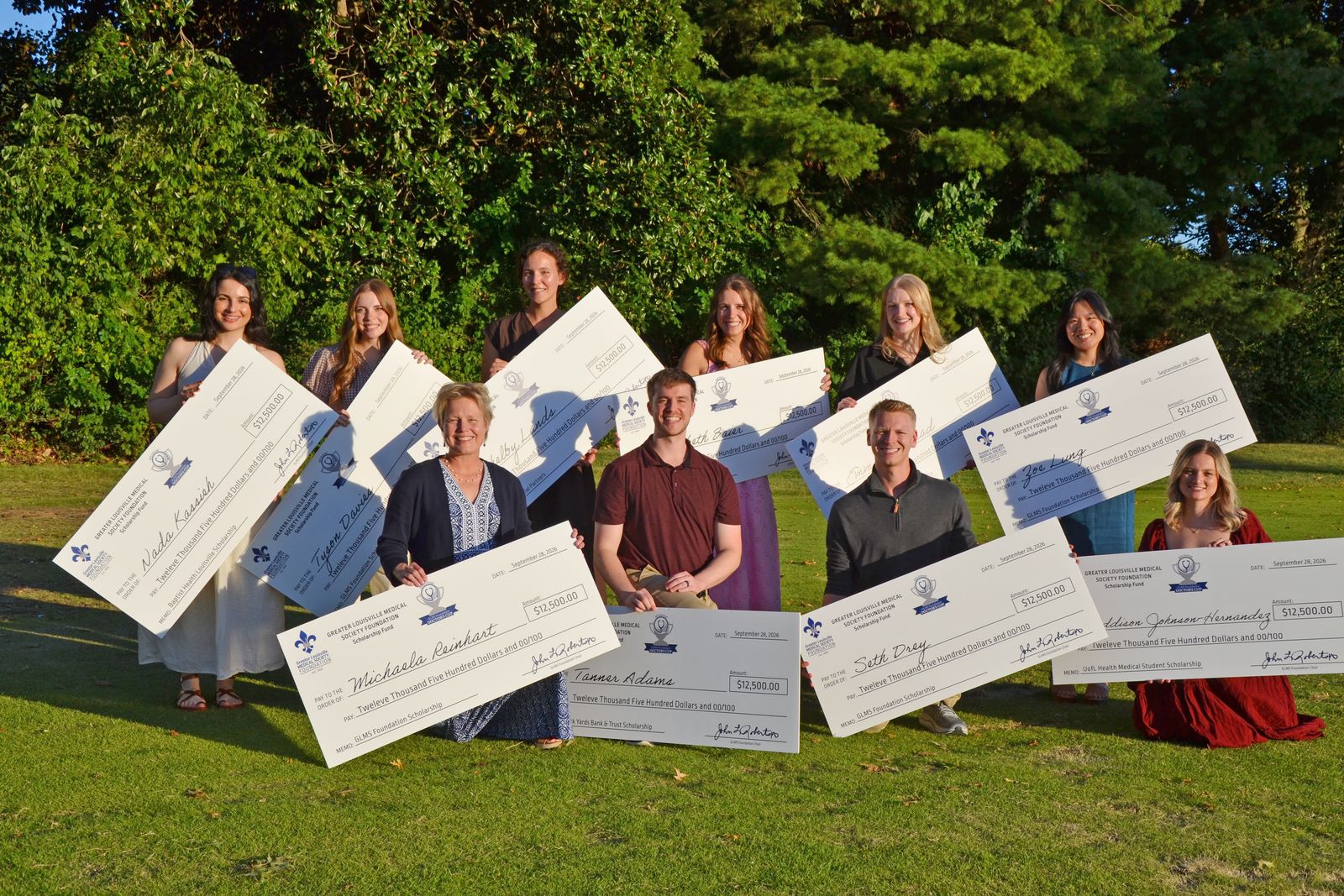 Scholarship recipients holding oversized checks