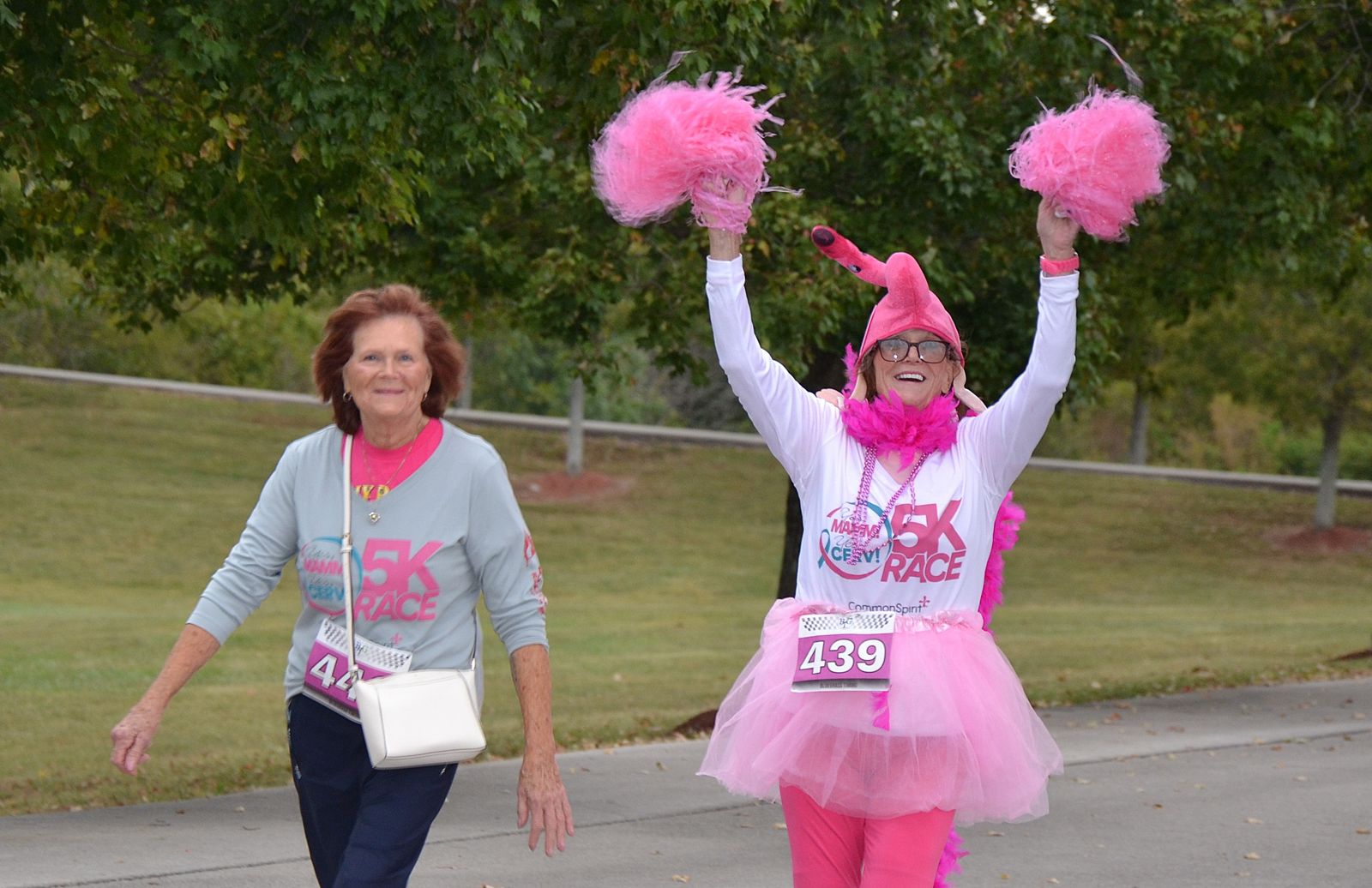 Runners in pink costumes with pom-poms