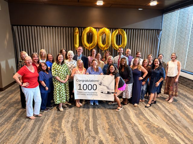 The Baptist Health lung cancer team with gold 1000 balloons