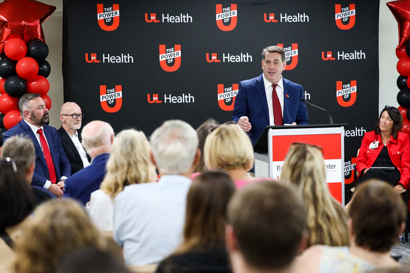 Jason Chesney, MD, PhD, speaking at a UofL Health podium